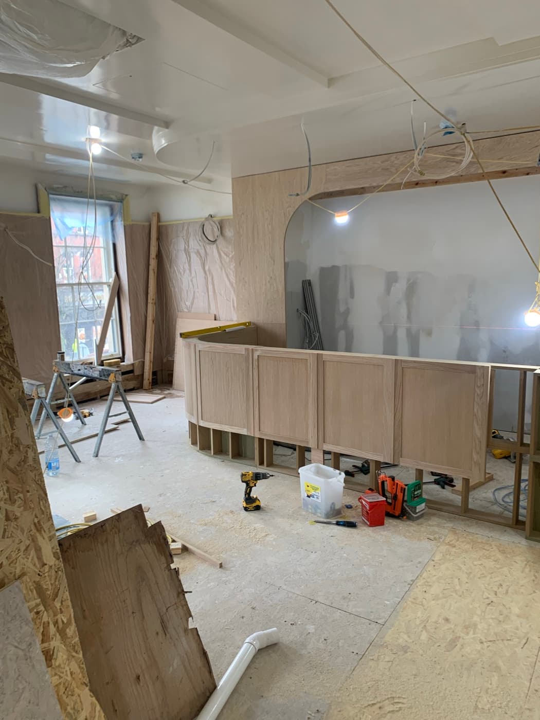 During the fit-out: The curved bar counter taking shape in front of the arched alcove, and the finished main bar.