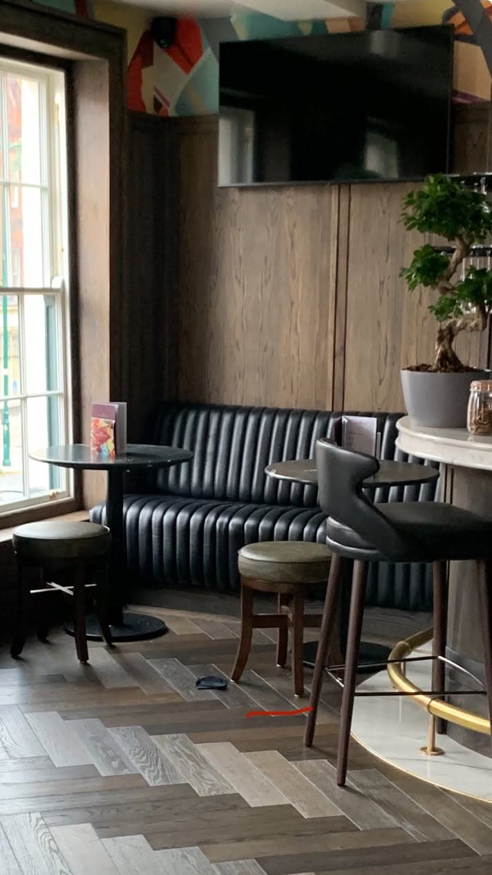 Channelled leather banquettes and high stools on the herringbone floor.